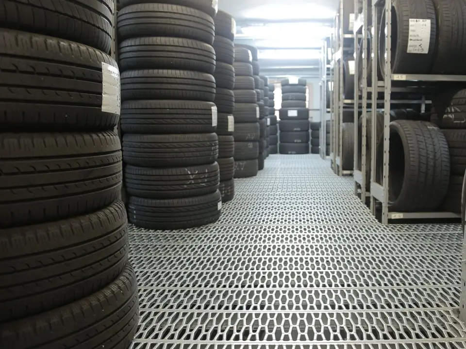 Aisle of a tire warehouse with stacked tires and storage racks